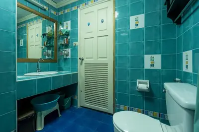 a blue bathroom with a toilet sink and a mirror at Condopatong in Patong Beach