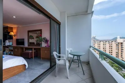 a bedroom with a balcony with a bed and a desk at Condopatong in Patong Beach