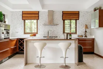 a kitchen with a large island with two white stools at Luxury 4BR Villa with Pool & Ocean Views on Patong in Patong Beach
