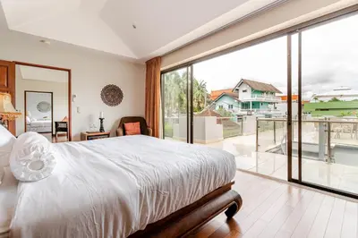 a bedroom with a large bed and a large window at Luxury 4BR Villa with Pool & Ocean Views on Patong in Patong Beach