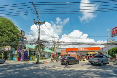 a city street with cars parked in front of stores at 3 Bedrooms villa walking distance to Rawai beach in Rawai Beach