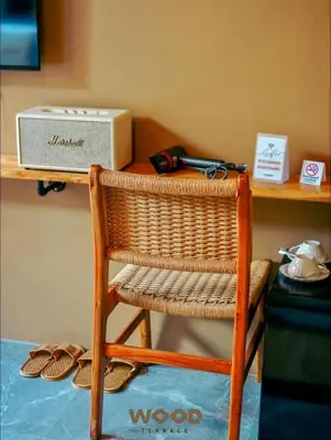 a wicker chair in front of a desk with a box at The Wood Terrace in Ban Chin Tham Mai