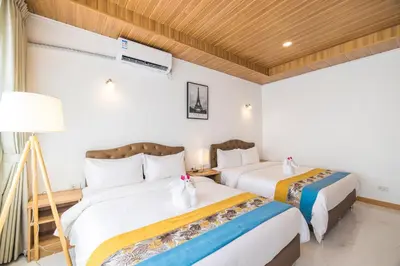 a hotel room with two beds and a lamp at Tongtong Garden Holiday Hotel\u666e\u5409\u5c9b\u901a\u901a\u82b1\u56ed\u9152\u5e97 in Rawai Beach
