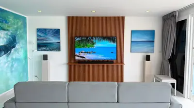a living room with a couch and a tv at Karon Butterfly Seaview Home in Phuket Town