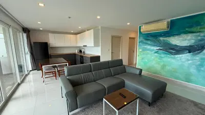 a living room with a couch and a kitchen at Karon Butterfly Seaview Home in Phuket Town