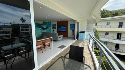 a balcony with a table and chairs on a building at Karon Butterfly Seaview Home in Phuket Town