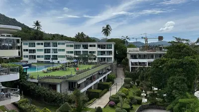 an apartment building with a tennis court in a courtyard at Karon Butterfly Seaview Home in Phuket Town