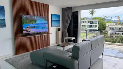 a living room with a couch and a tv at Karon Butterfly Seaview Home in Phuket Town