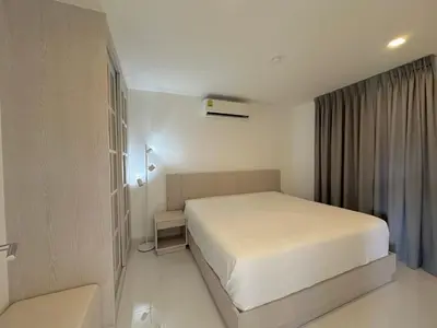 a bedroom with a white bed in a room at Karon Butterfly Seaview Home in Phuket Town