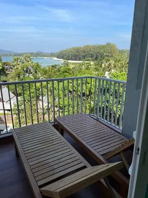a balcony with a bench and a view of the ocean at Beachfront Bliss at Naiyang Phuket by ALPHATEL in Phuket