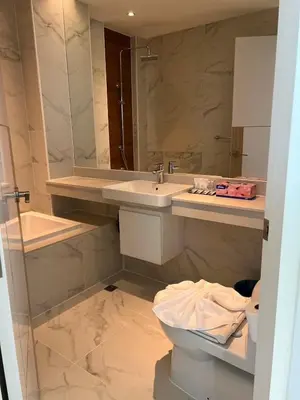 a bathroom with a sink and a toilet and a mirror at Beachfront Bliss at Naiyang Phuket by ALPHATEL in Phuket