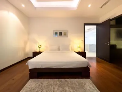 a bedroom with a bed with white sheets and a window at Charming 3-bdr apartment with pool in Bang Tao Beach