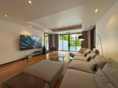 a living room with two couches and a flat screen tv at Charming 3-bdr apartment with pool in Bang Tao Beach