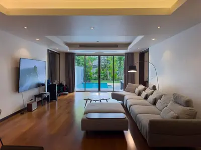 a living room with a couch and a flat screen tv at Charming 3-bdr apartment with pool in Bang Tao Beach