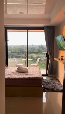 a bedroom with a bed and a large window at Sunset Room Phuket in Ban Mai Salae