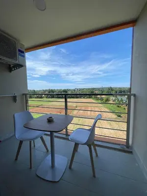 a table and two chairs in a room with a large window at Sunset Room Phuket in Ban Mai Salae