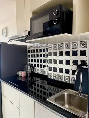 a kitchen counter with a sink and a microwave at Sunset Room Phuket in Ban Mai Salae