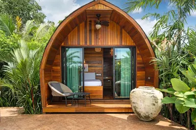a small wooden room with a bed and a chair at Tropical Chalet-Style 2BR Villa with Pool Pasak Paradise 2, Bangtao in Bang Tao Beach
