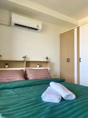 a bedroom with a green bed with two pillows on it at Cozy Room Phuket in Ban Mai Salae
