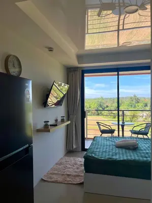 a bedroom with a bed and a balcony with a view at Cozy Room Phuket in Ban Mai Salae