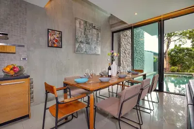 a dining room with a wooden table and chairs at Private & Modern 4BR Pool Villa Otero, 3 Levels of Comfort with Greenery Views, Kamala in Kamala Beach