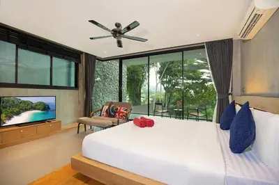 a bedroom with a bed with a ceiling fan and a television at Private & Modern 4BR Pool Villa Otero, 3 Levels of Comfort with Greenery Views, Kamala in Kamala Beach