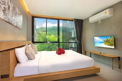 a bedroom with a large white bed and a window at Private & Modern 4BR Pool Villa Otero, 3 Levels of Comfort with Greenery Views, Kamala in Kamala Beach