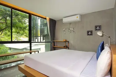 a bedroom with a white bed and a window at Private & Modern 4BR Pool Villa Otero, 3 Levels of Comfort with Greenery Views, Kamala in Kamala Beach