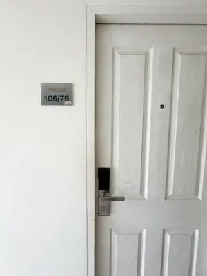 a white door with a sign on it at Bukitta Airport Condominium by Sutanee in Ban Bo Han