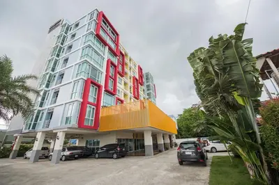 a large building with cars parked in front of it at Bukitta Airport Condominium by Sutanee in Ban Bo Han