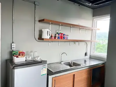 a small kitchen with a sink and a refrigerator at Bukitta Airport Condominium by Sutanee in Ban Bo Han