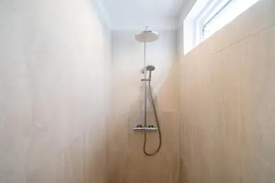 a shower with a shower head in a bathroom at Villa with swimming pool in Ravai 17 in Ban Saiyuan (1)