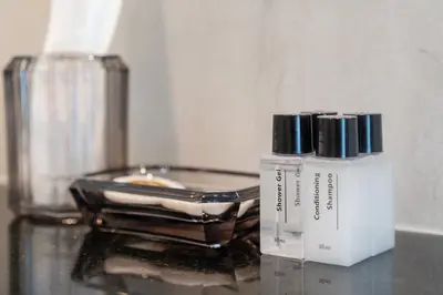 a bottle of cosmetics sitting on a glass table at Villa with swimming pool in Ravai 17 in Ban Saiyuan (1)
