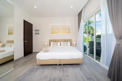 a bedroom with a bed and a large window at Villa with swimming pool in Ravai 17 in Ban Saiyuan (1)