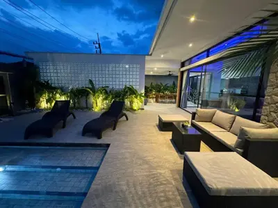 a patio with a couch and chairs and a pool at Luciana Villa by G Estate Phuket in Rawai Beach