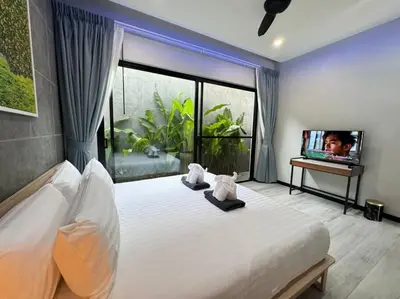 a bedroom with a large bed and a television at Luciana Villa by G Estate Phuket in Rawai Beach