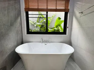 a white bath tub in a bathroom with a window at Luciana Villa by G Estate Phuket in Rawai Beach