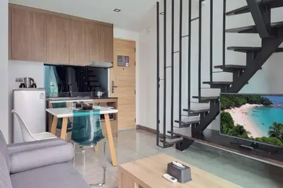 a living room with a tv and a kitchen at Perfect Holiday Spot - Pool View Duplex in Tropical Naiharn! UTL A310 in Rawai Beach