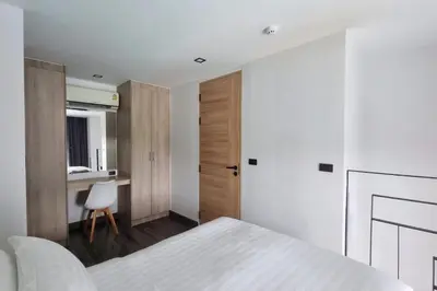 a bedroom with a white bed and a desk at Perfect Holiday Spot - Pool View Duplex in Tropical Naiharn! UTL A310 in Rawai Beach