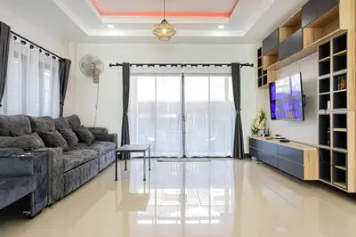 a living room with a couch and a television at Kathu V pool villa 171 in Kathu