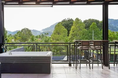 a balcony with a bath tub and a table and chairs at Kathu V pool villa 171 in Kathu