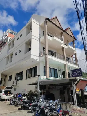 a white building with motorcycles parked in front of it at L&K2023 Residence in Patong Beach