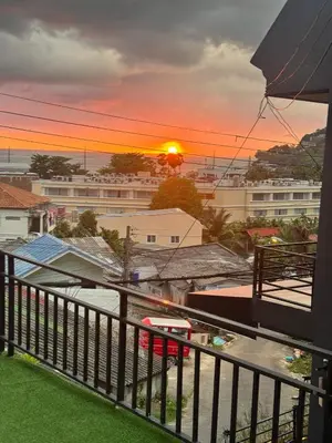 a view of a sunset from a balcony at Rinda House Patong 31-1 in Patong Beach