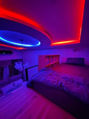 a bedroom with a bed with red and blue lights at Rinda House Patong 31-1 in Patong Beach