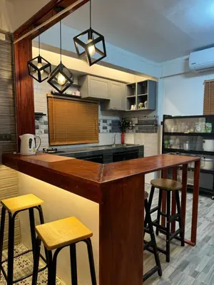 a kitchen with a wooden counter and stools at Rinda House Patong 31-1 in Patong Beach