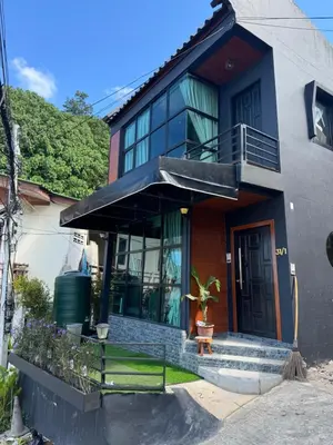 a house with a black door and a balcony at Rinda House Patong 31-1 in Patong Beach
