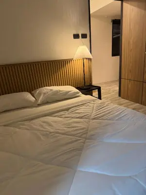 a large white bed in a room with a lamp at Rinda House Patong 31-1 in Patong Beach