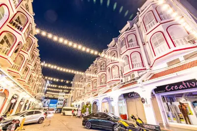 a row of buildings with cars parked on a street at Queen On Street Guest House in Ban Lo Long