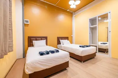 a room with two beds and a mirror at Queen On Street Guest House in Ban Lo Long