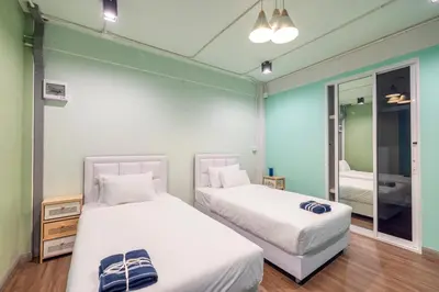 two beds in a room with a mirror at Queen On Street Guest House in Ban Lo Long